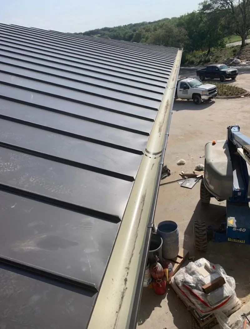 Standing seam panel and gutter detail on a metal roofing jobsite in Defiance